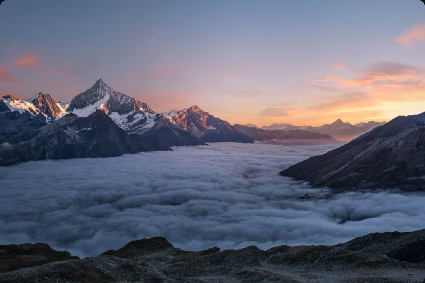 Alpine peaks at sunset above a sea of clouds